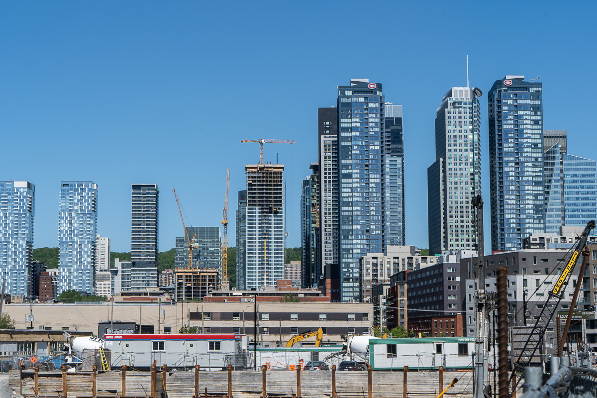 Près d'un chantier de Griffintown, des grues sont visibles autour des grattes-ciel du centre-ville de Montréal.