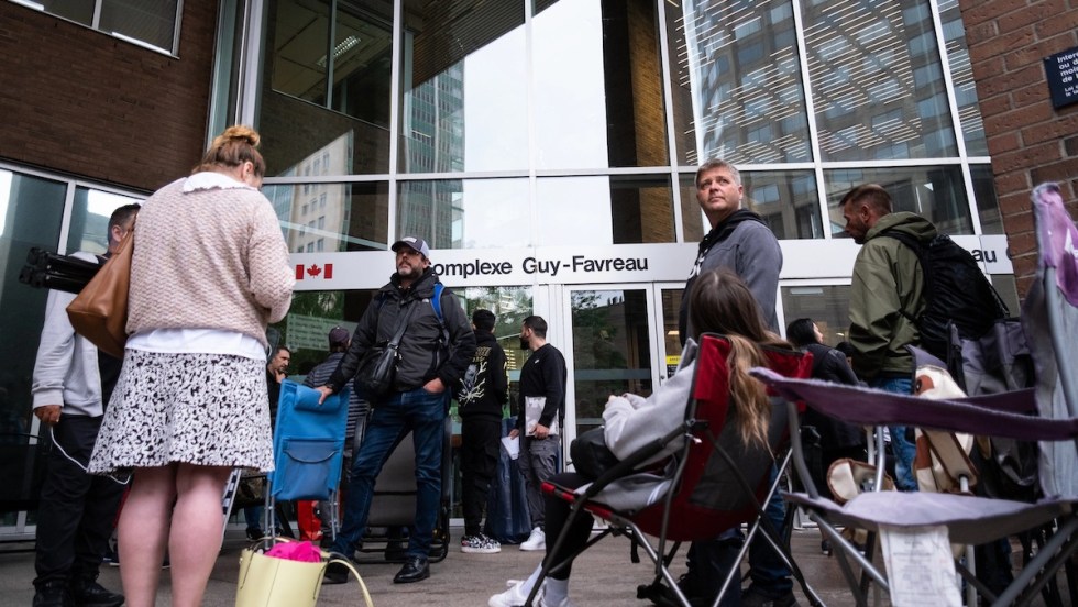 Une foule de citoyens dans une file d'attente pour obtenir un passeport devant le Complexe Guy-Favreau, à Montréal.