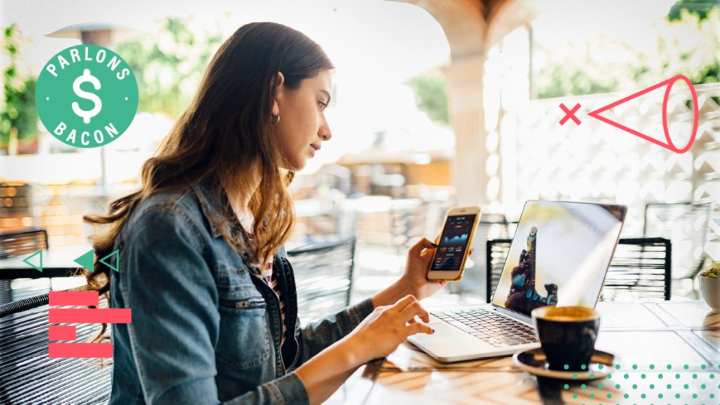 Une femme regarde ses finances personnelles sur son téléphone et son ordinateur à l'approche de la réglementation prévue des cryptomonnaies.