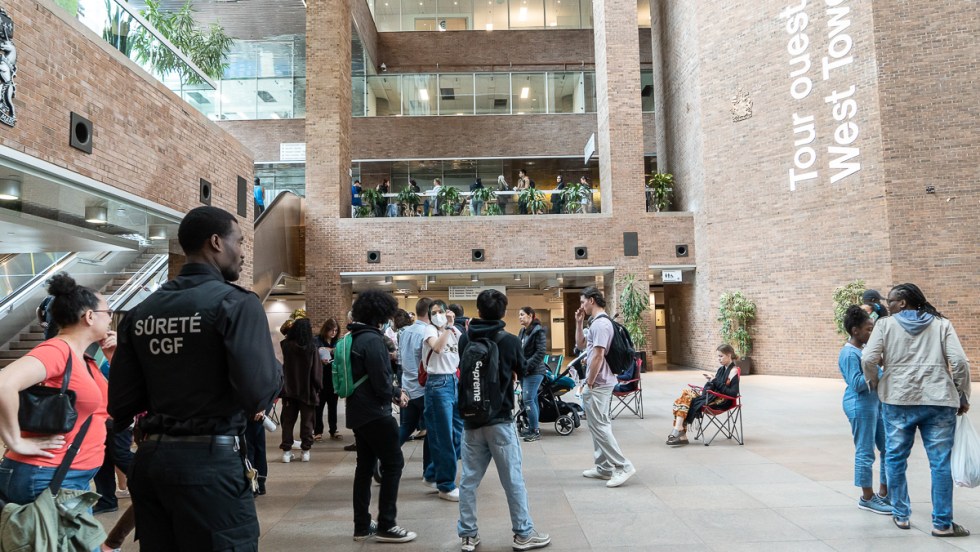 Des centaines de personnes attendent en file devant les bureaux de Service Canada, au complexe Guy-Favreau, afin d'obtenir un passeport.