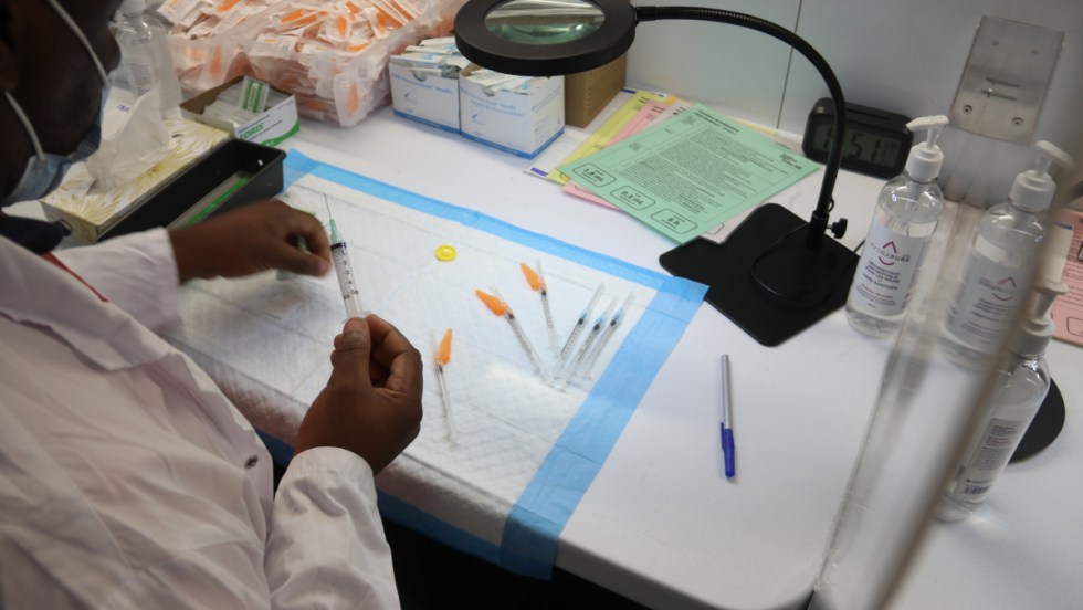 Un homme préparant les doses de vaccin.