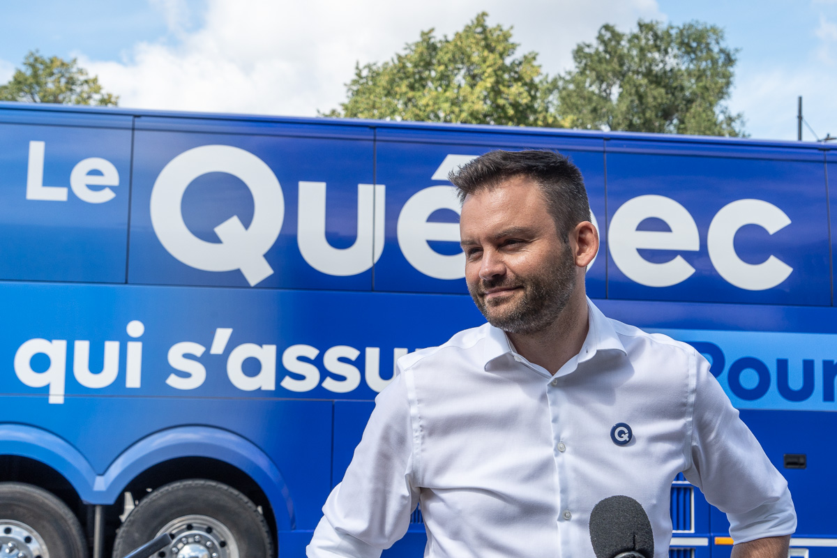 Paul St-Pierre Plamondon devant l'autobus de campagne du PQ.