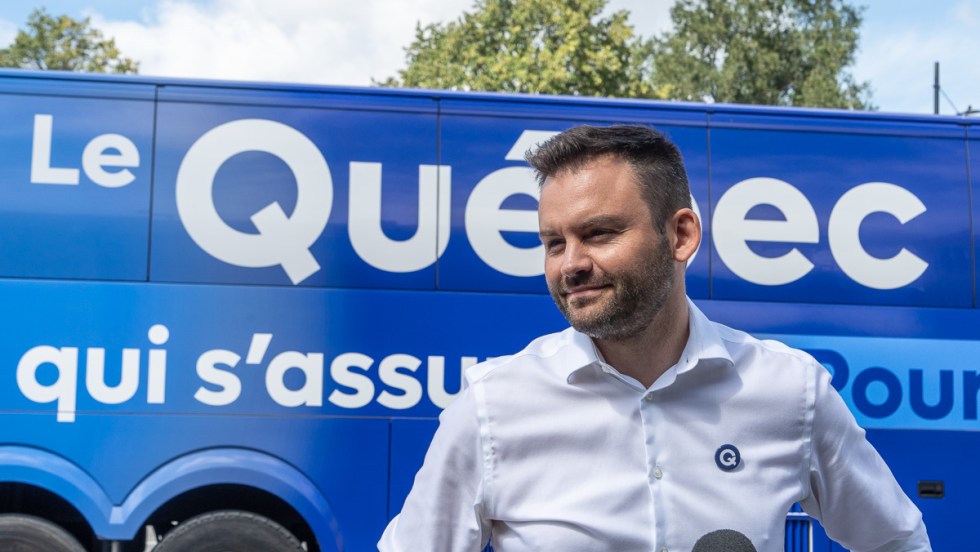 Paul St-Pierre Plamondon devant l'autobus de campagne du PQ.