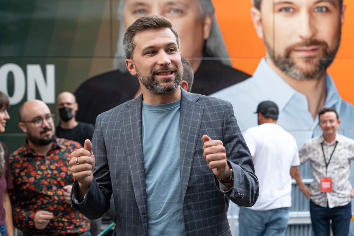 Gabriel Nadeau-Dubois, coporte-parole de Québec solidaire, devant une affiche de lui-même et de Manon Massé.