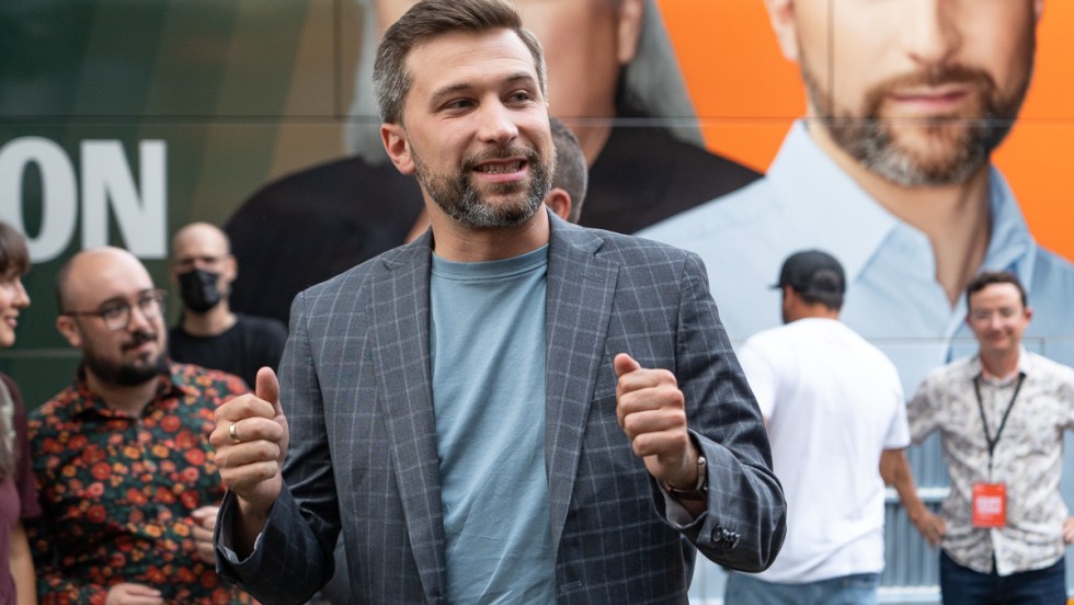 Gabriel Nadeau-Dubois, coporte-parole de Québec solidaire, devant une affiche de lui-même et de Manon Massé.