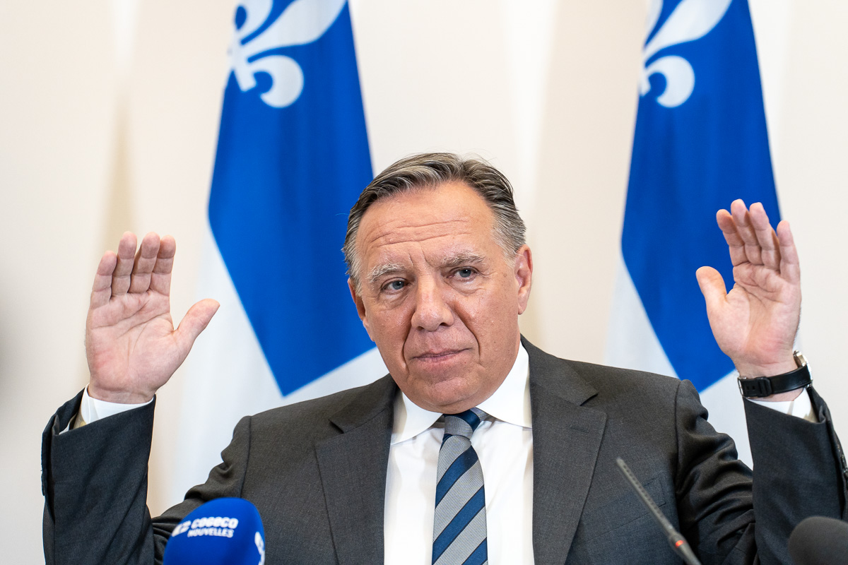 François Legault, chef de la CAQ, devant des drapeaux du Québec.