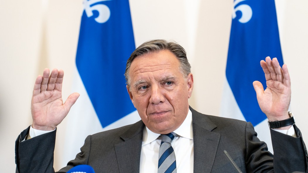 François Legault, chef de la CAQ, devant des drapeaux du Québec.